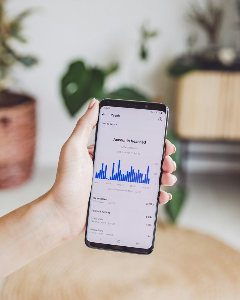 Person using budgeting app on smartphone instead of pen and paper