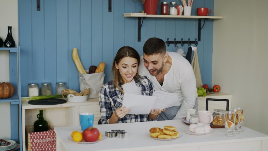 Couple reviewing household budget together at kitchen table