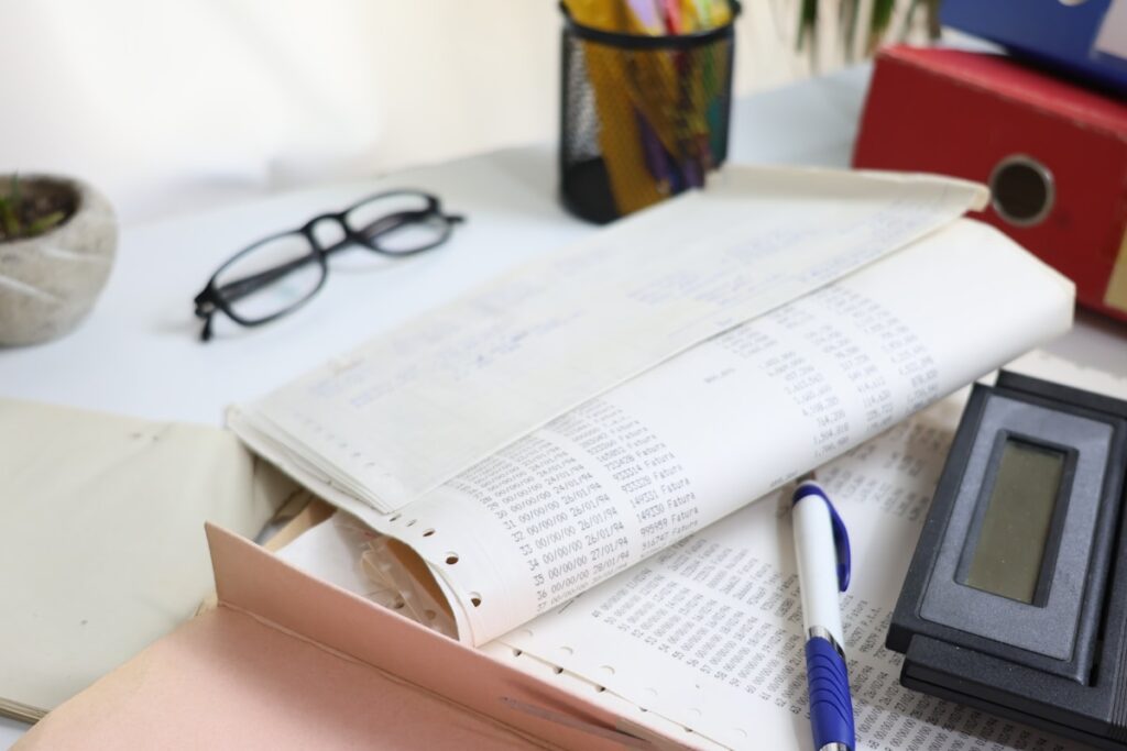 Desk with financial plan documents, calculator, and supplies