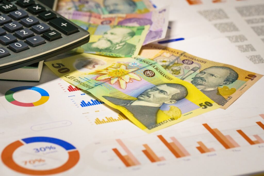 Calculator on stack of bills using the 50/30/20 rule