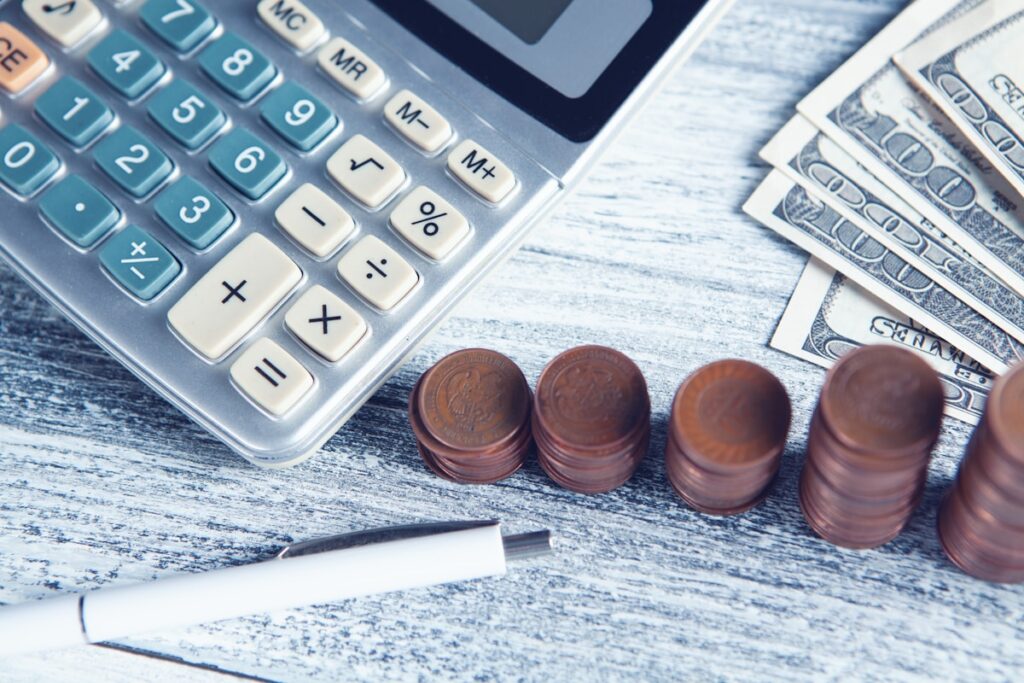 Calculator, pen, and money on a table for mastering finances