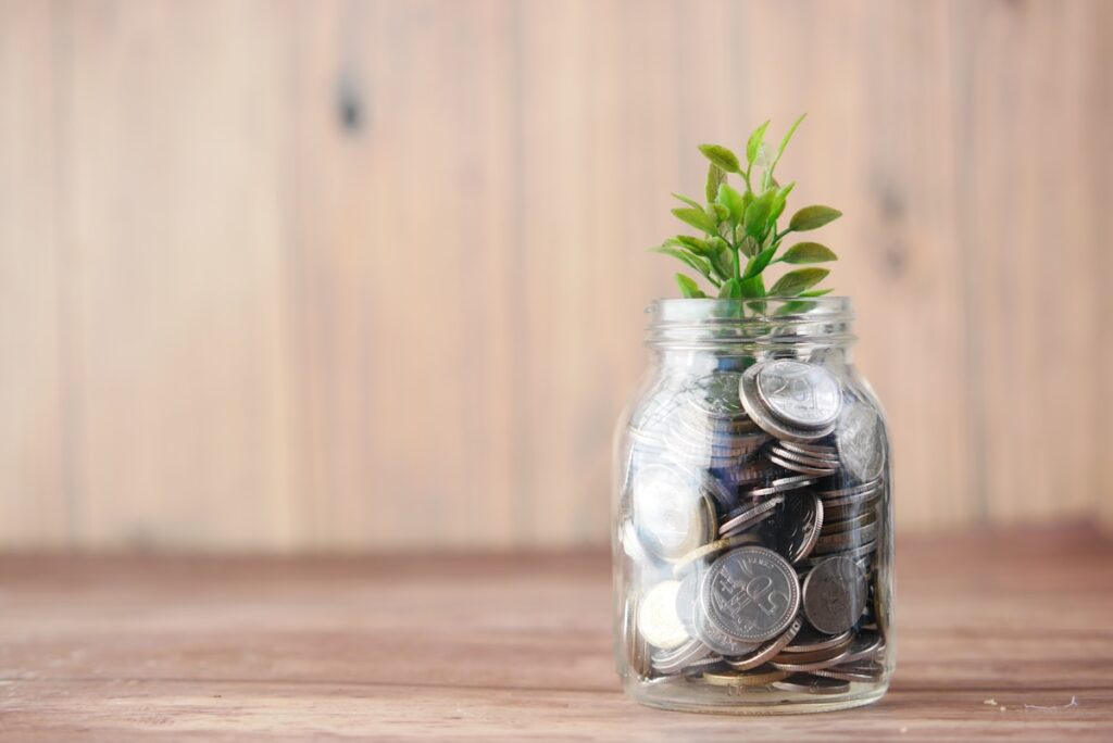 Glass jar of coins growing through a savings challenge