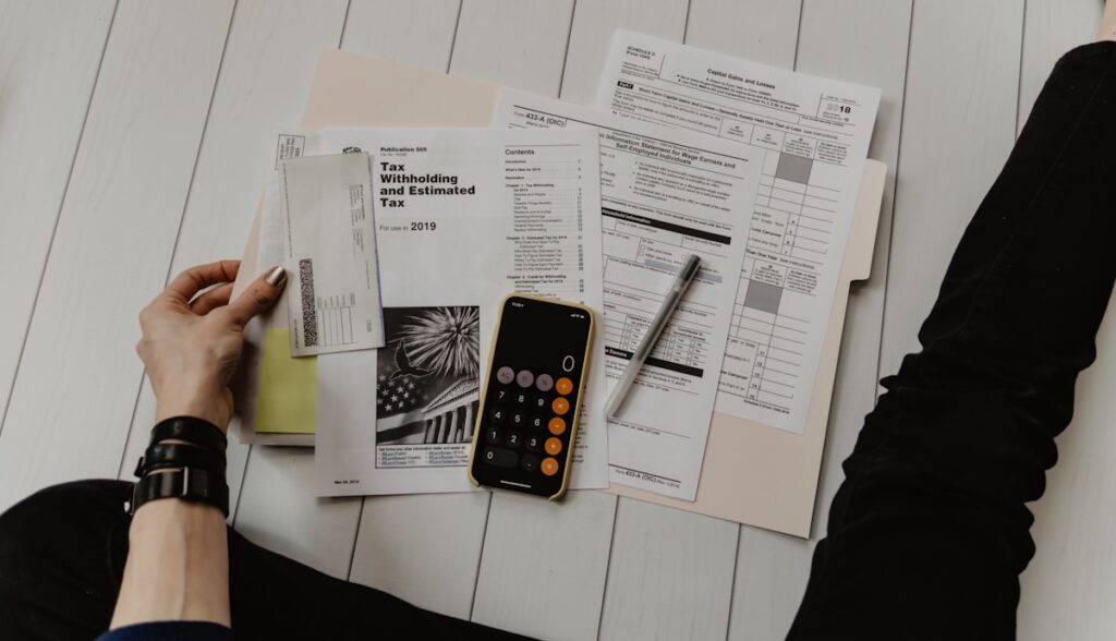 Beginner writing first budget with calculator, paper and pen