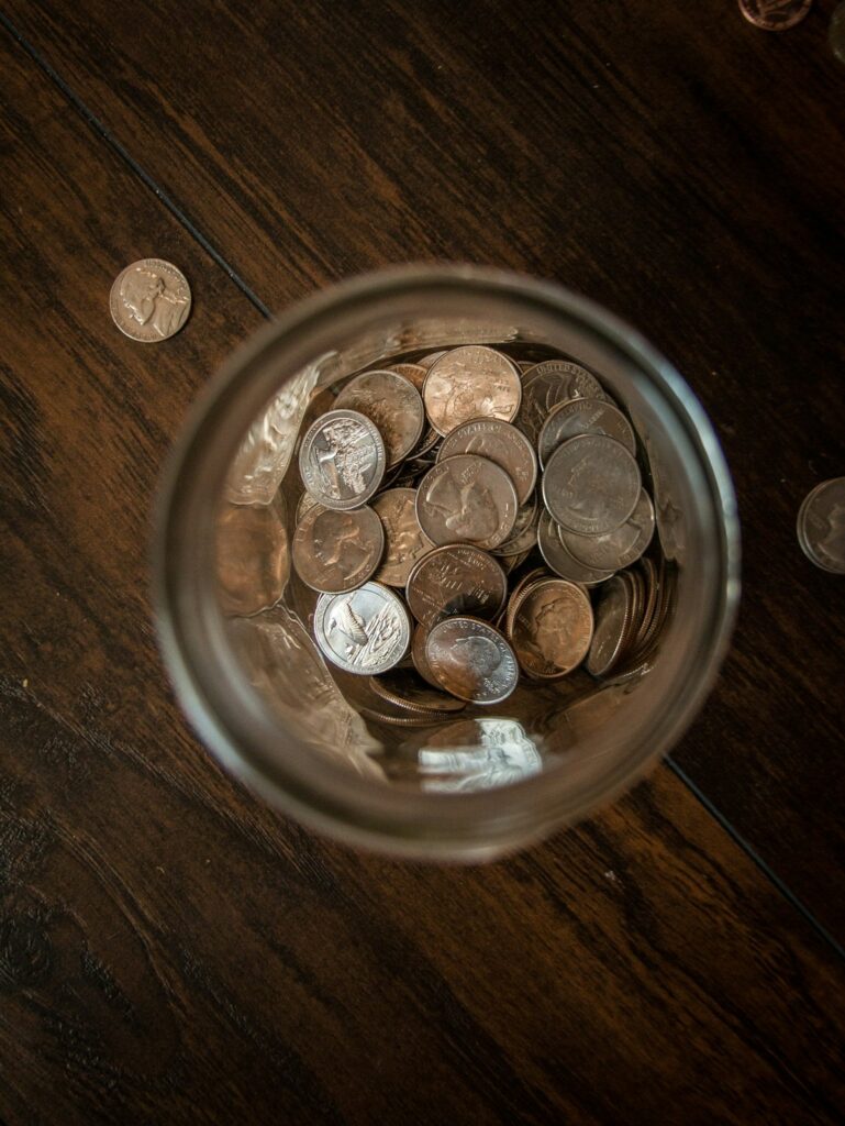 Coins in a glass jar teaching teens money-saving habits